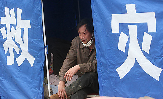 图文:获救者坐在救援帐篷内